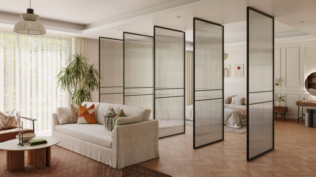 Six black-framed glass panels forming a rotatable center pivot door in a modern living room with beige sofa and plants.